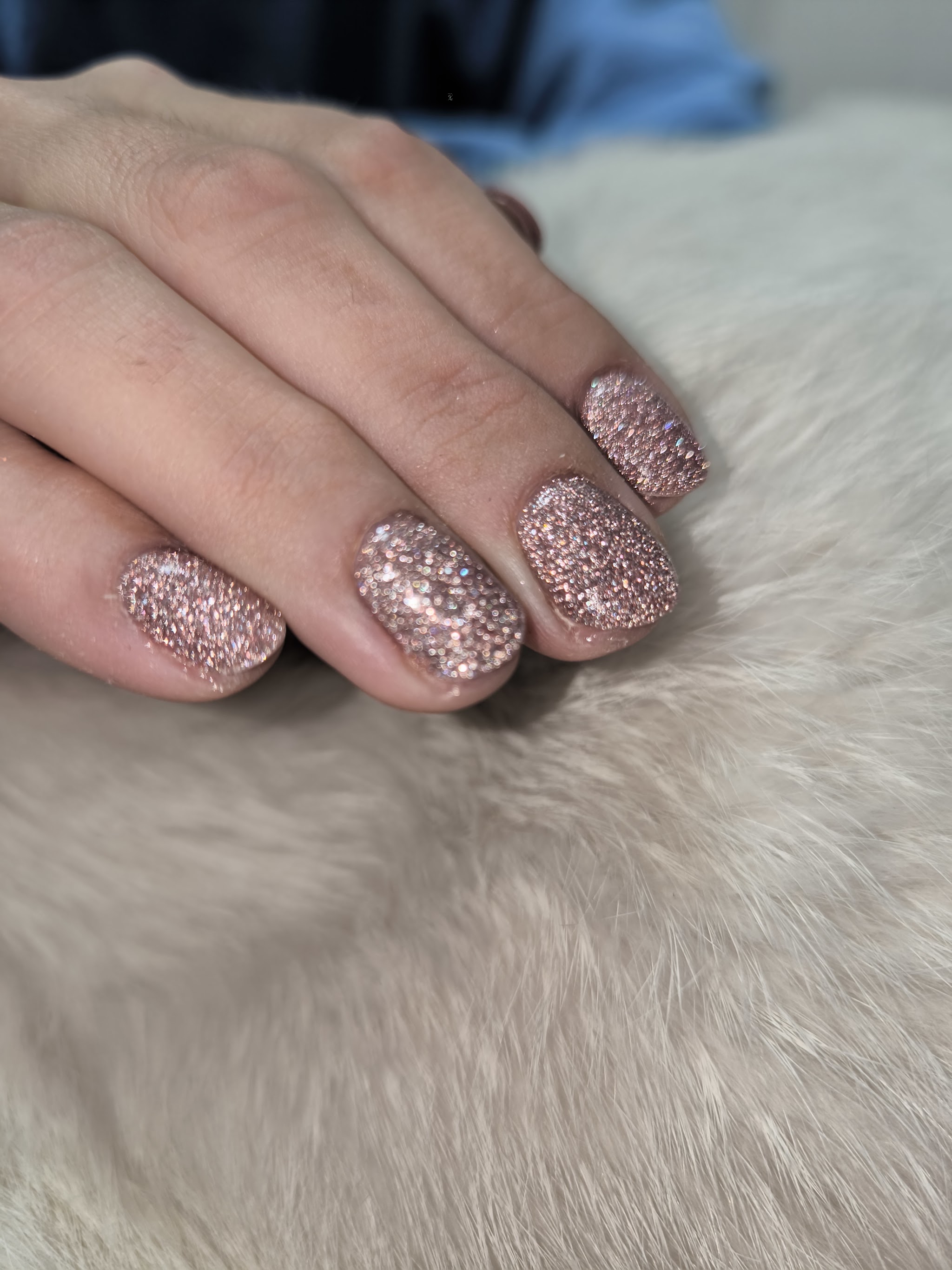 Korte nagels met roze glitter op wit bont