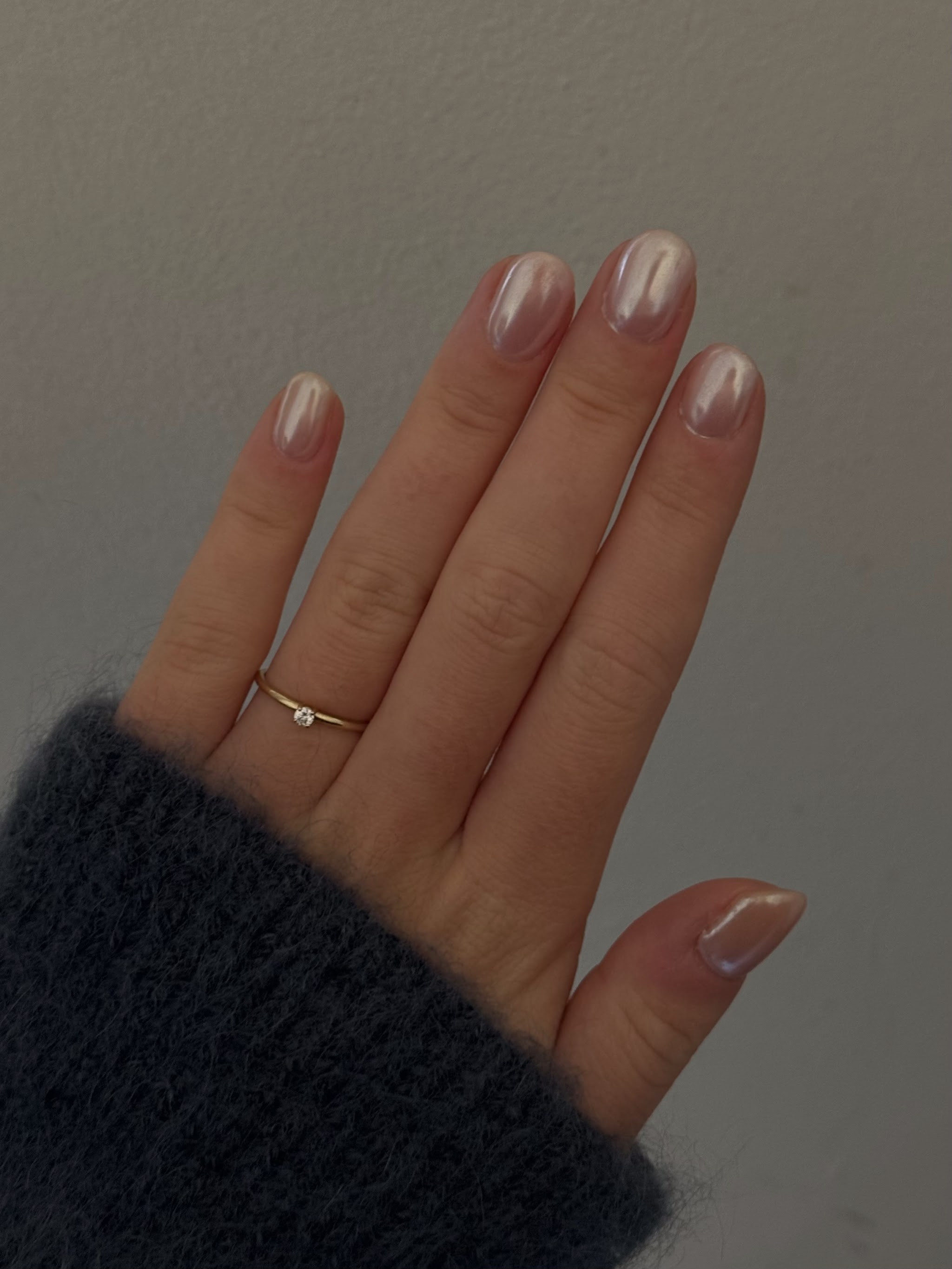 Chrome over nude nagels, hand in een gebreide mouw